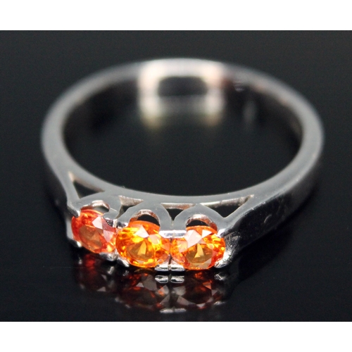 205 - A three stone fancy orange sapphire ring, hallmarked 9ct white gold band, sponsor's initials 'DK', B... 