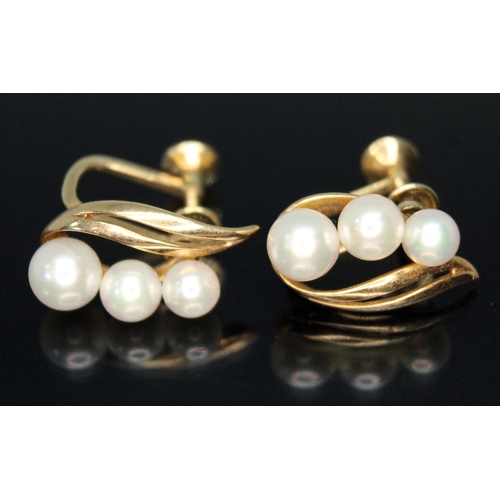 206 - A pair of Mikimoto cultured pearl earrings, each elipipse shapded earring set with three graduated p... 