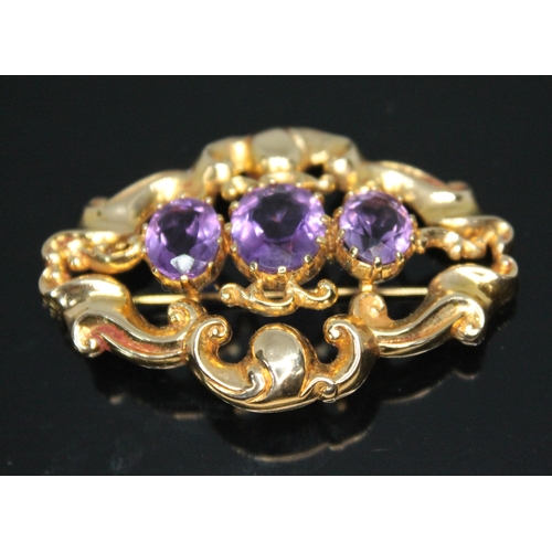 207 - A 9ct gold brooch of scroll form and set with three oval amethysts, 52mm x 36mm, hallmarked 9ct gold... 