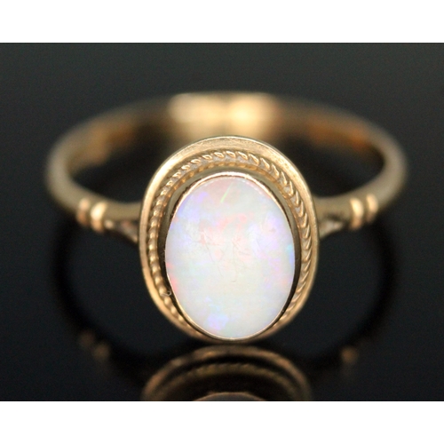 264 - A hallmarked 9ct gold ring set with an oval precious opal cabochon, gross weight 1.66g, size O.