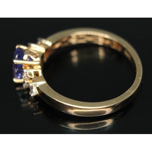 329 - A tanzanite and diamond ring, the central oval mixed cut stone weighing approx. 1.35 carats, mounted... 