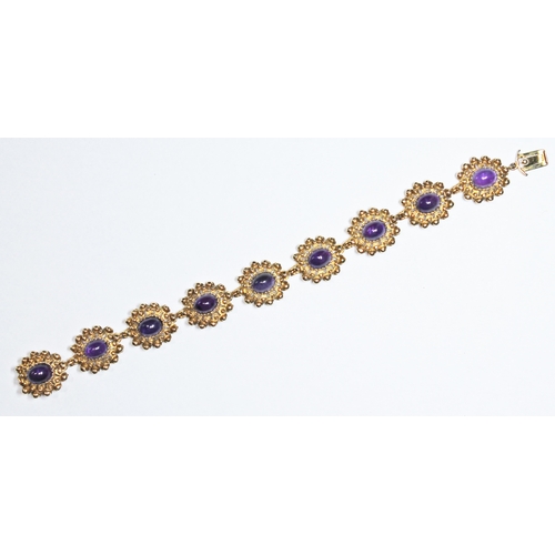 348 - A contemporary gold and amethyst bracelet featuring nine flower head links each set with an amethyst... 