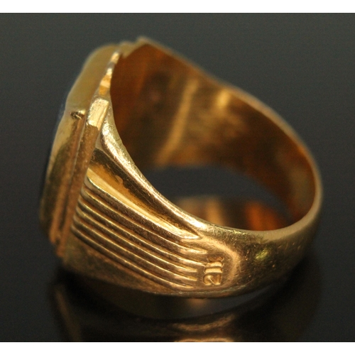 372 - An eastern ring marked '21K' and set with a hematite slab, gross weight 16.42g, size U.