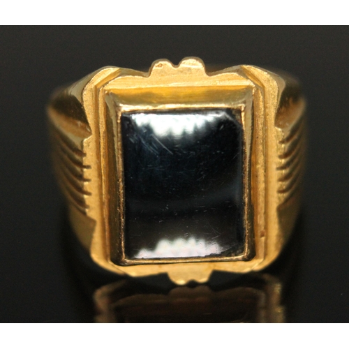 372 - An eastern ring marked '21K' and set with a hematite slab, gross weight 16.42g, size U.