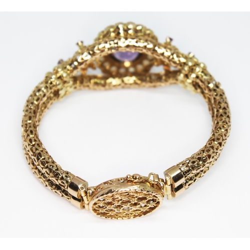 419 - A 9ct gold bracelet set with an oval cut amethyst weighing approx. 9.94 carats and surrounded by twe... 