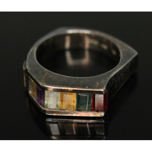 132B - A modernist multi gemstone ring featuring channel set baguette cut stones including garnet, emerald,... 