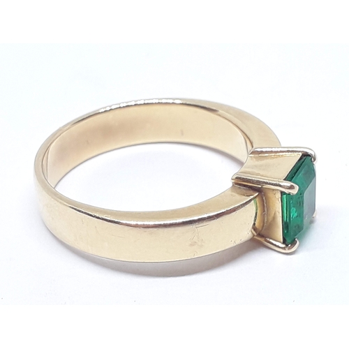 134 - A emerald ring, the rectangular emerald cut emerald weighing approx. 0.73 carats, the band marked '1... 