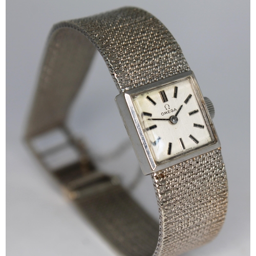 135 - A 1970 hallmarked 9ct white gold Omega ladies wristwatch 7115698, with integrated 9ct white gold str... 