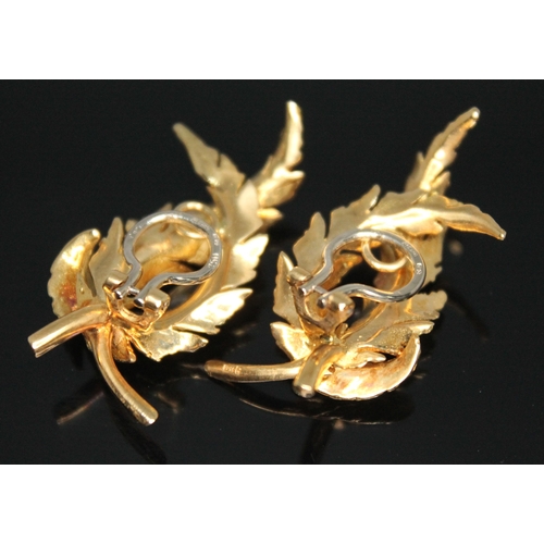 173 - A pair of 18ct gold clip on earrings, each naturalistically modelled as a pair of curved laurel wrea... 