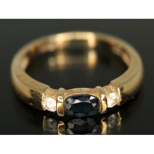 203 - A hallmarked 18ct gold sapphire and colourless stone ring, gross wt. 4.14g, size O.