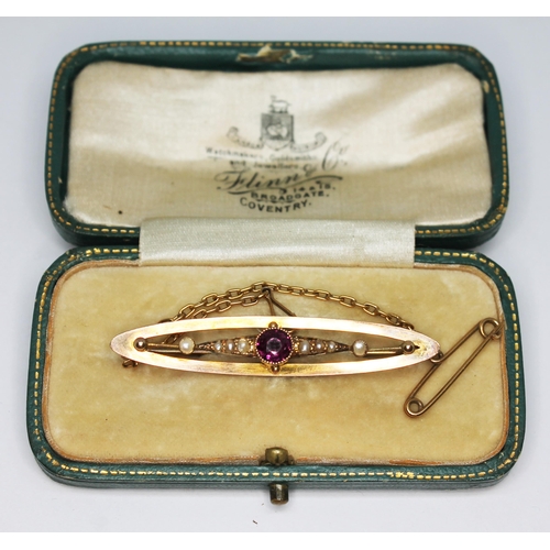 207 - A n early 20th century brooch set with a central purple garnet and split pearls, marked 9ct, gross w... 