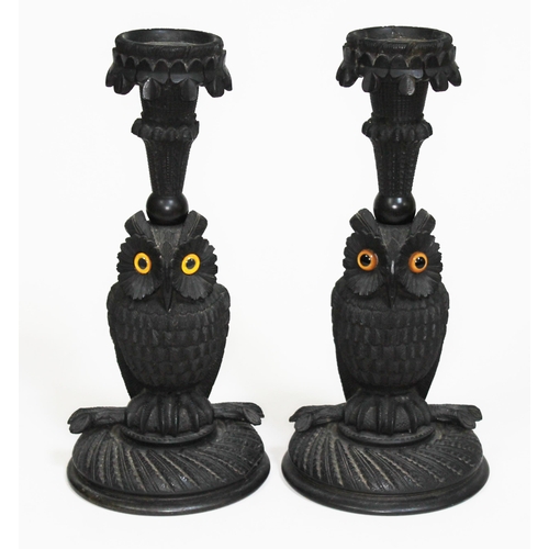 362 - A pair of Irish bog oak candlesticks modelled as owls, with sconce above having carved clovers, circ... 