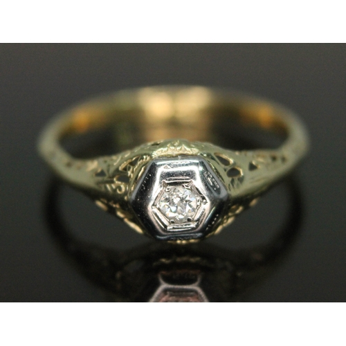 109 - A diamond solitaire ring, hexagonal bezel above open work setting and shoulders, band marked '18ct',... 