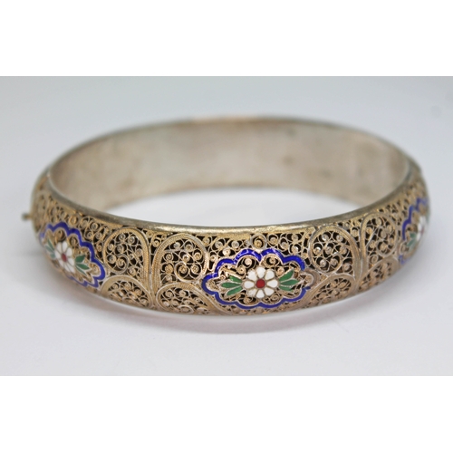 157 - A white and gilt metal filigree bangle with enamel decoration, indistinctly marked, diam. approx. 58... 