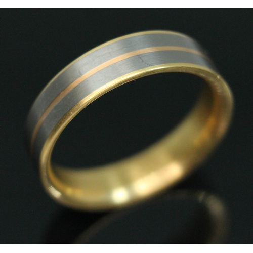 63 - A yellow metal and titanium wedding band by Feniom, inverted D section, marked 'AU750', gross wt. 5.... 