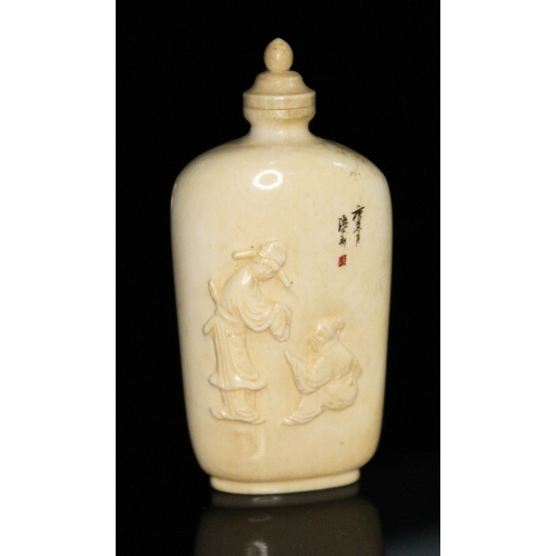 332 - A Chinese ivory snuff bottle, one side carved in relief with two figures, the other decorated with a... 