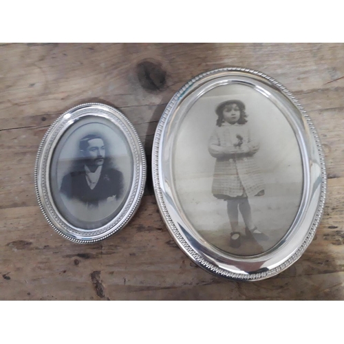 416 - Two hallmarked silver oval photograph frames, 11cm x 14cm & 17cm x 22cm.