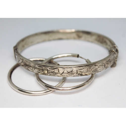 459 - A silver bangle and a pair of silver earrings.