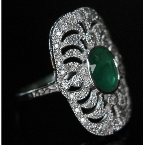 149 - An 18ct white gold emerald and diamond ring, the central oval cut emerald approx. 1.08ct, surround b... 