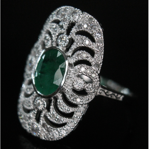 149 - An 18ct white gold emerald and diamond ring, the central oval cut emerald approx. 1.08ct, surround b... 