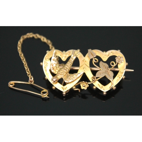 126 - An Edwardian double heart brooch mounted with flowers and a swallow, marked '9ct', length 31mm, weig... 