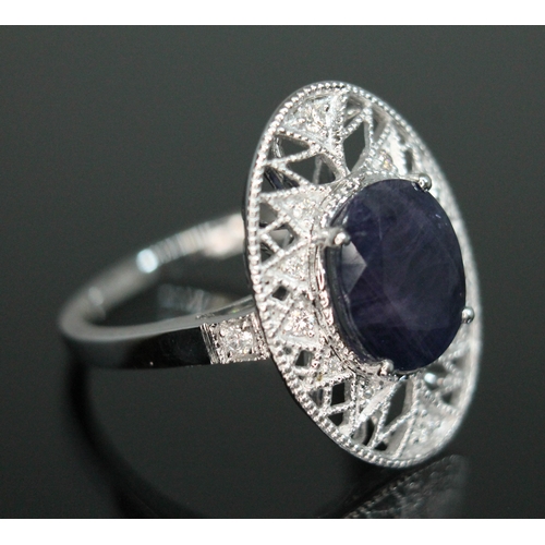 148 - A fancy purple sapphire and diamond cluster ring, the oval cut central stone weighing approx. 3.45ct... 