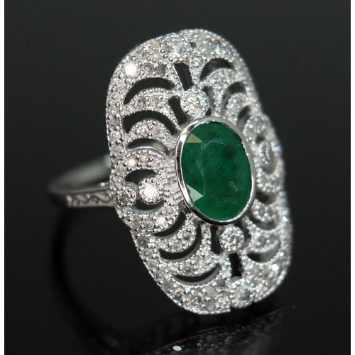 149 - An 18ct white gold emerald and diamond ring, the central oval cut emerald approx. 1.08ct, surround b... 