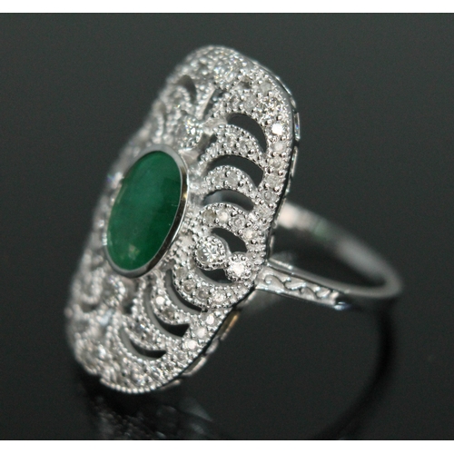 149 - An 18ct white gold emerald and diamond ring, the central oval cut emerald approx. 1.08ct, surround b... 