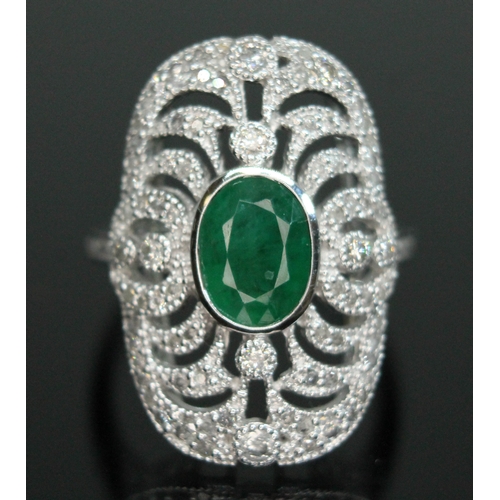 149 - An 18ct white gold emerald and diamond ring, the central oval cut emerald approx. 1.08ct, surround b... 