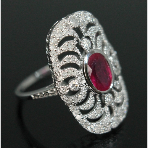 152 - A ruby and diamond cluster ring, the bezel set oval cut ruby weighing approx. 0.91 carats, surrounde... 