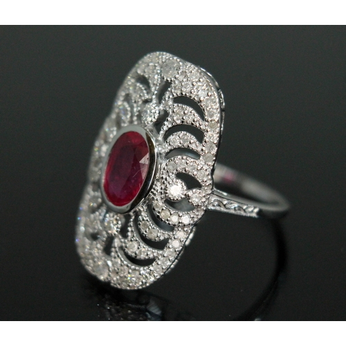 152 - A ruby and diamond cluster ring, the bezel set oval cut ruby weighing approx. 0.91 carats, surrounde... 