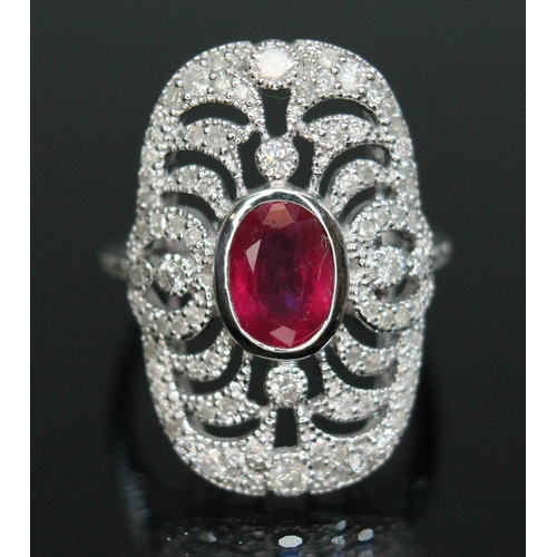 152 - A ruby and diamond cluster ring, the bezel set oval cut ruby weighing approx. 0.91 carats, surrounde... 