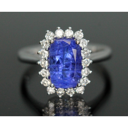 153 - A tanzanite and diamond cluster ring, the four claw set cushion cut tanzanite weighing approx. 3 car... 