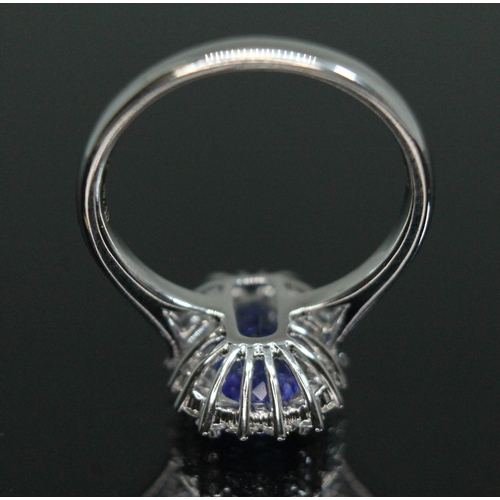 153 - A tanzanite and diamond cluster ring, the four claw set cushion cut tanzanite weighing approx. 3 car... 