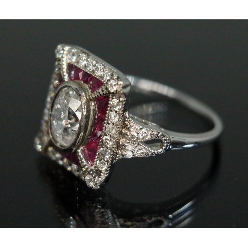 158 - A diamond and ruby cluster ring, the central bezel set oval cut diamond weighing approx. 1 carat, su... 