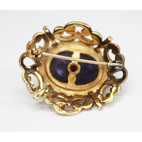 188 - A 9ct gold amethyst and seed pearl brooch, formed as a deep oval amethyst cabochon mounted with a st... 