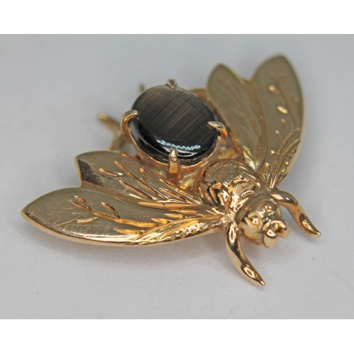 249 - A novelty brooch modelled as a bee and set with a synthetic six ray star sapphire, marked '14K' and ... 