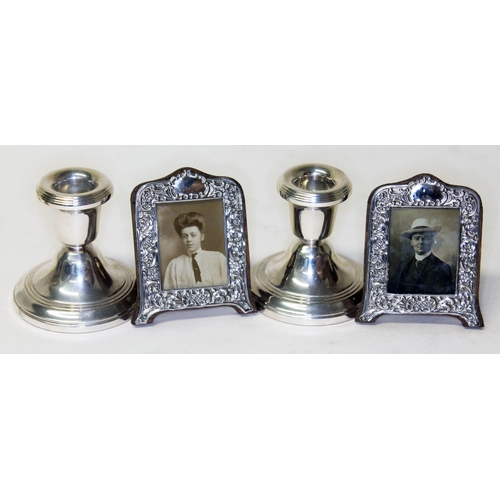 294 - Hallmarked silver comprising a pair of miniature photograph frames and a pair of candle stands.