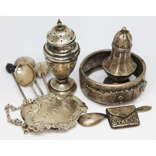 38 - Assorted hallmarked silver comprising a stamp case, two pepperettes, a port decanter label, four bea... 