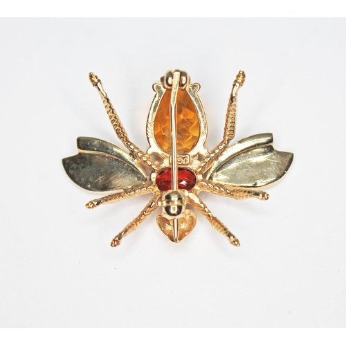 109 - A novelty brooch modelled as a bee and set with a citrine and a garnet, marked '10K', length 3.42g.