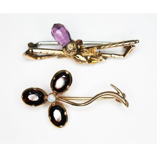 115 - A hallmarked 9ct gold brooch formed as two crossed golf clubs and mounted with an amethyst thistle l... 