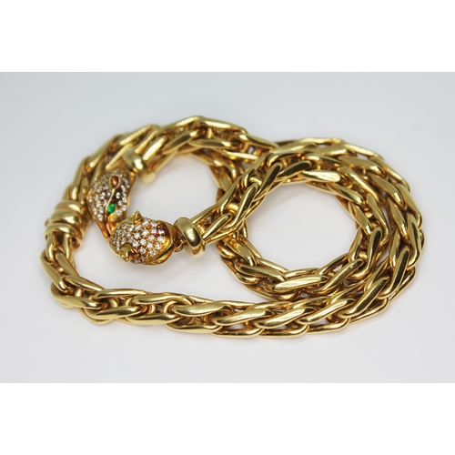 121 - A choker necklace, the fancy link chain joined by two pave set diamond panther heads with emeralds f... 