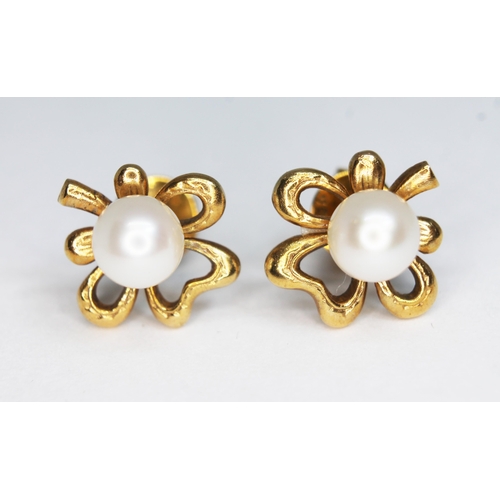 132 - A pair of cultured pearl set earrings modelled as stylised clovers, the butterflies marked '18K', gr... 