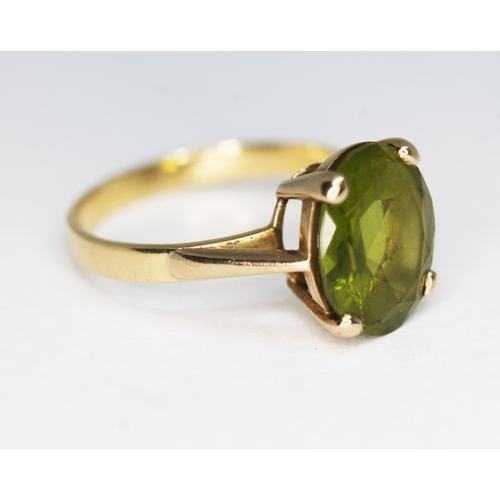 149 - A hallmarked 9ct gold ring set with an oval cut peridot weighing approx. 4.23 carats, gross wt. 3.52... 