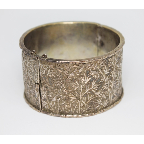 175 - A Chinese silver bangle, the exterior decorated with bees amongst bamboo, indistinct two character m... 