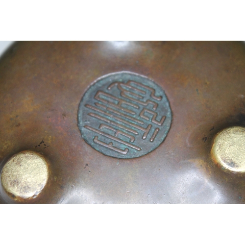 206 - A Chinese bronze censor, three footed, round seal mark to base, diam. 11cm.