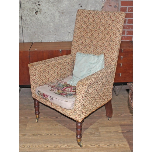 34 - A George IV high back armchair with turned mahogany legs and brass castors.