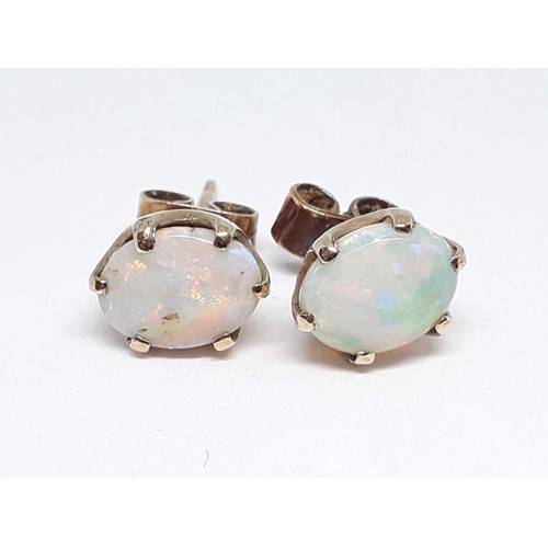 168 - A pair of hallmarked 9ct gold precious opal stud earrings, each cabochon measuring approx. 8mm x 6mm... 