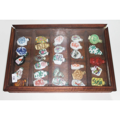 130 - A collection of 28 modern Chinese snuff bottles in display.