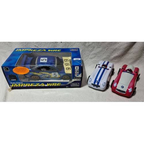 255 - An RC Subaru Impreza car and 2 tin cars.